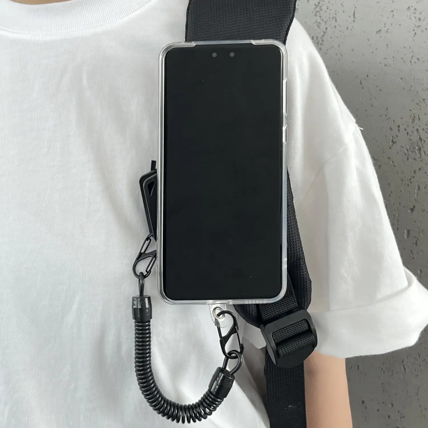 Schwarzer Telefonriemen mit gewelltem Kordelzug und Metallverschlüssen, entwickelt, um ein iPhone für die magnetische Telefon-Rucksackclip Universalhalterung zu sichern.