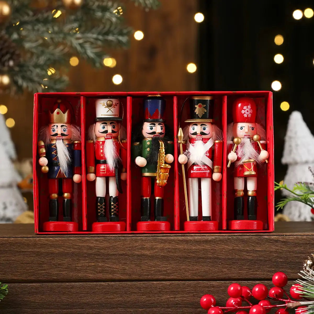 Juego de cinco figurines de cascanueces de madera en uniformes de estilo militar, exhibidos en una caja roja para su uso como decoración de árbol de Navidad.
