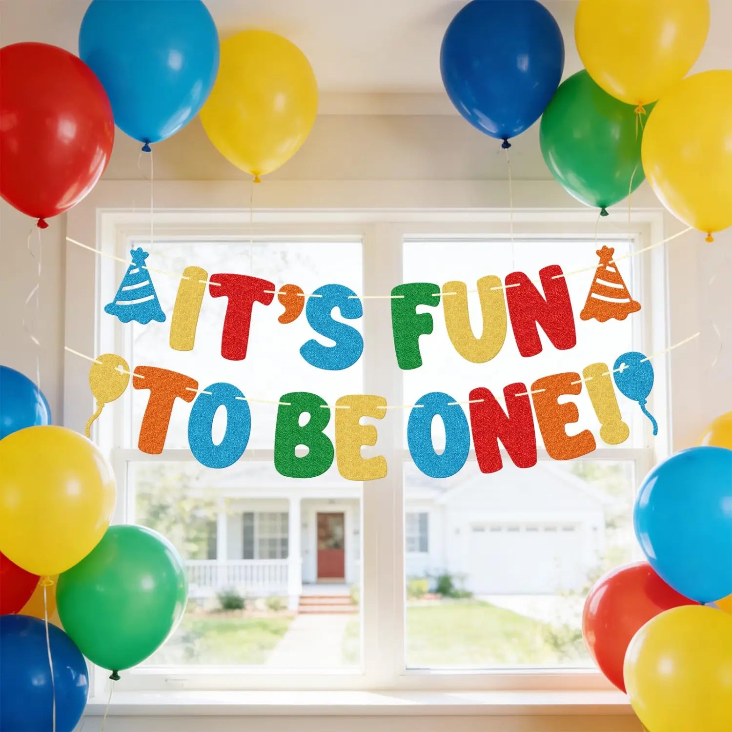 Bunt schimmerndes Glitzer-Banner zum ersten Geburtstag mit der Aufschrift „Es macht Spaß, eins zu sein“ mit Partyhütchen- und Ballon-Dekorationen für die Partydavon