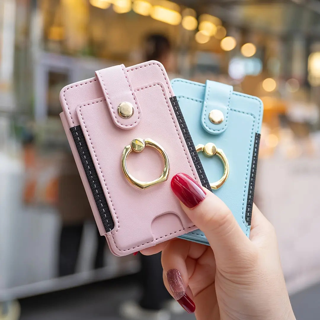 Pink and light blue leather universal ring small card holders for smartphones with gold-tone ring grips shown from a top-front angle.