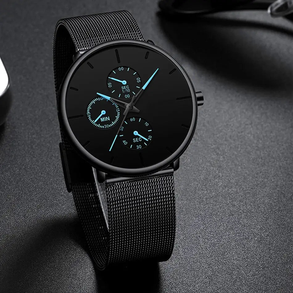 Montre à quartz à maille noire ultrafine pour hommes, avec un design minimaliste élégant, trois sous-cadrans et des aiguilles bleu lumineux.