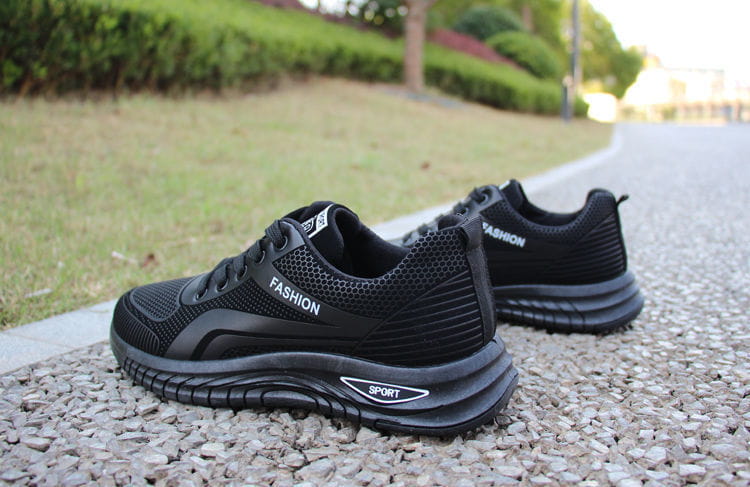 Men breathable athletic sneakers running shoes in black mesh and synthetic leather with fashion branding on the side and sport logo on the sole.