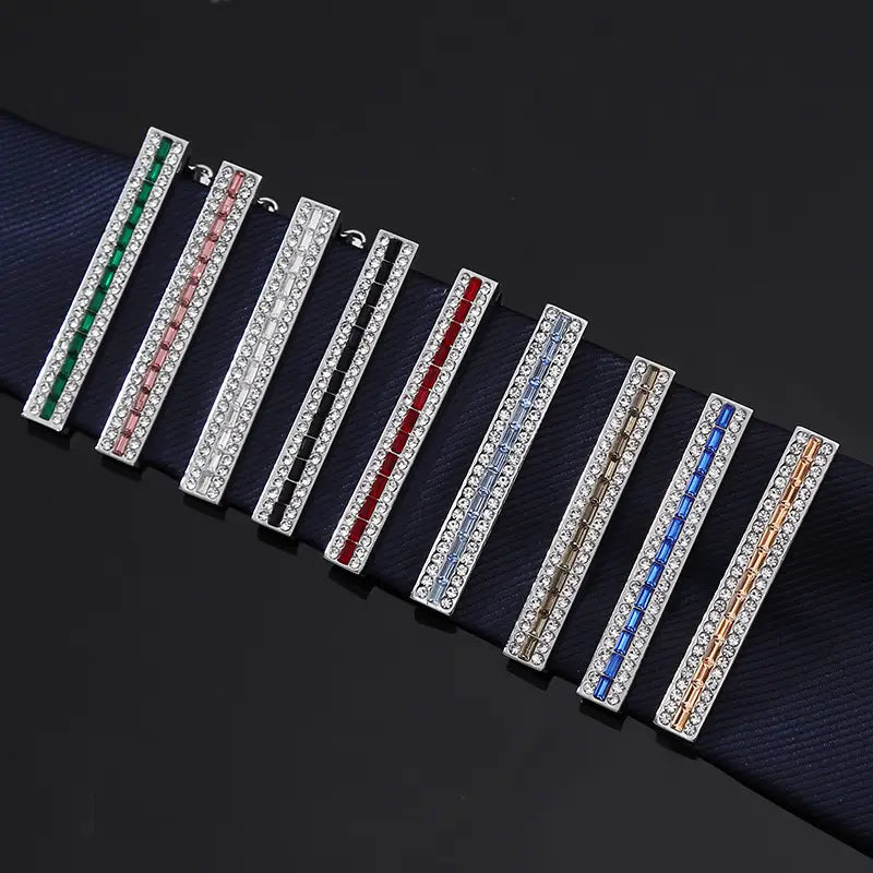 A set of eight rectangular crystal rhinestone tie clips in various colors including green, pink, black, red, blue, and gold.