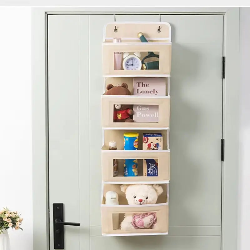 Organisateur monté sur la porte en tissu beige avec six poches à façade transparente pour un rangement suspendu au-dessus de la porte, dans un design de bac en tissu gris