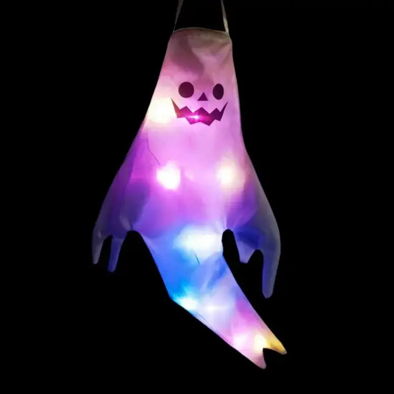 A glowing purple and blue led halloween ghost lantern made of translucent fabric with a smiling face for home outdoor hanging use.