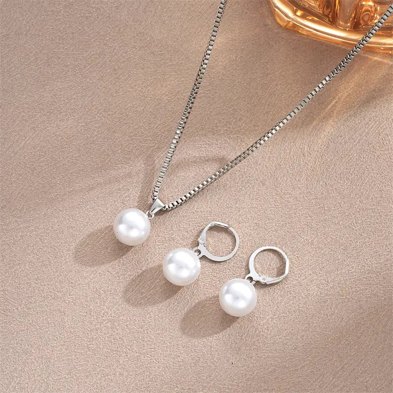 Silver-toned necklace and matching hoop earrings set featuring a single round white pearl each in a pearl jewelry set gold necklace and earrings.