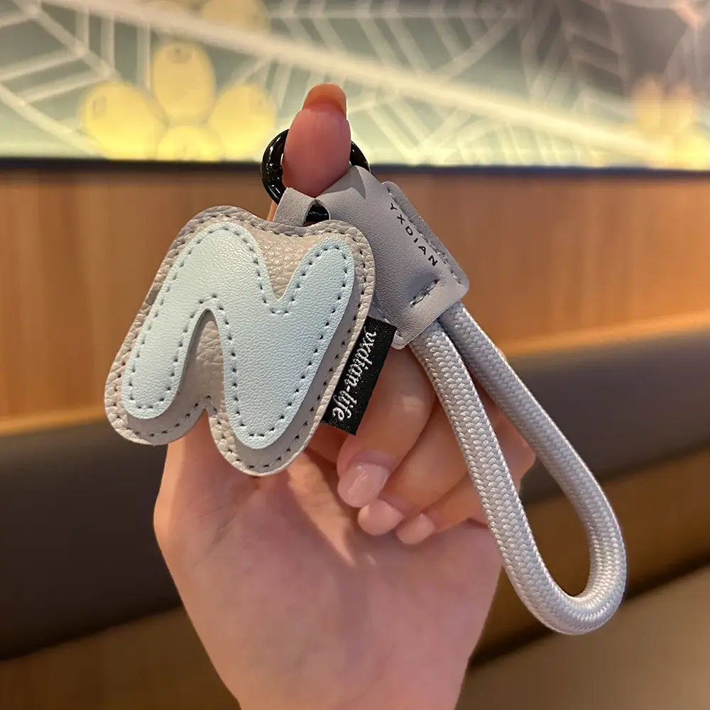 Light blue leather initial keychain letter wristband charm with stitched edges and a silver braided cord featuring the letter m.