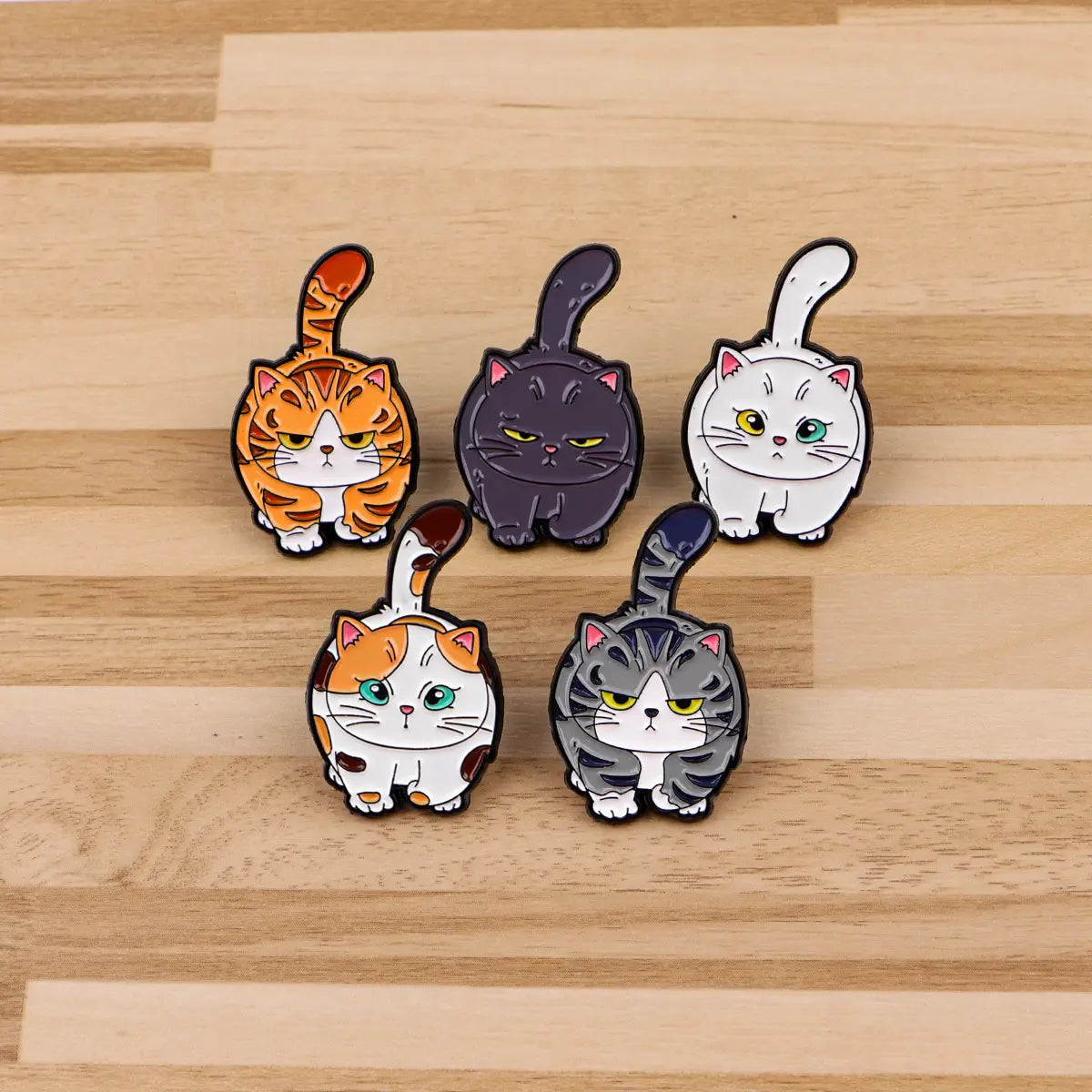 Set of five colorful cartoon-style cat enamel lapel pins featuring expressive faces and detailed fur patterns.