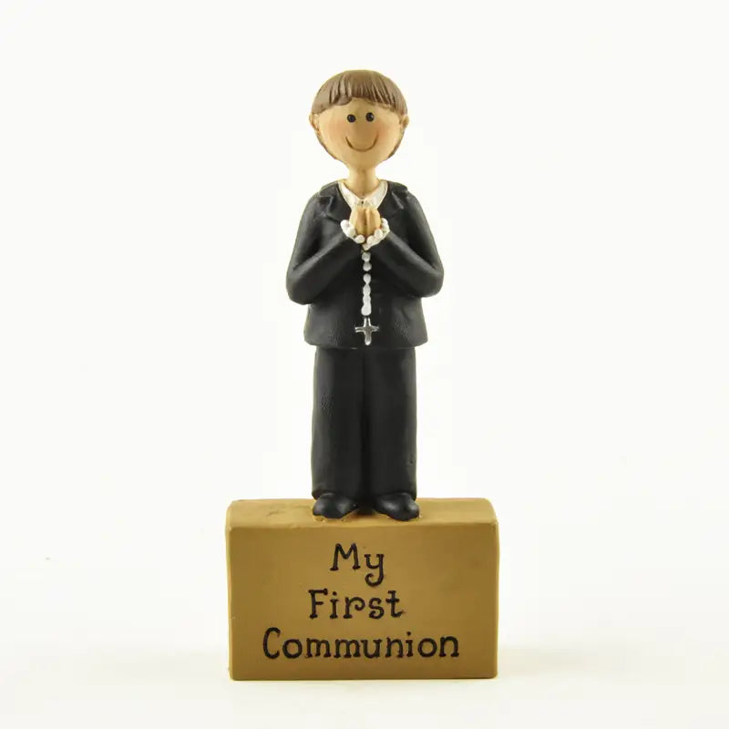 figurine de garçon de première communion en résine, décoration de table, représentant un garçon noir souriant en tenue de cérémonie tenant des perles de chapelet sur une base beige gravée « ma première communion »