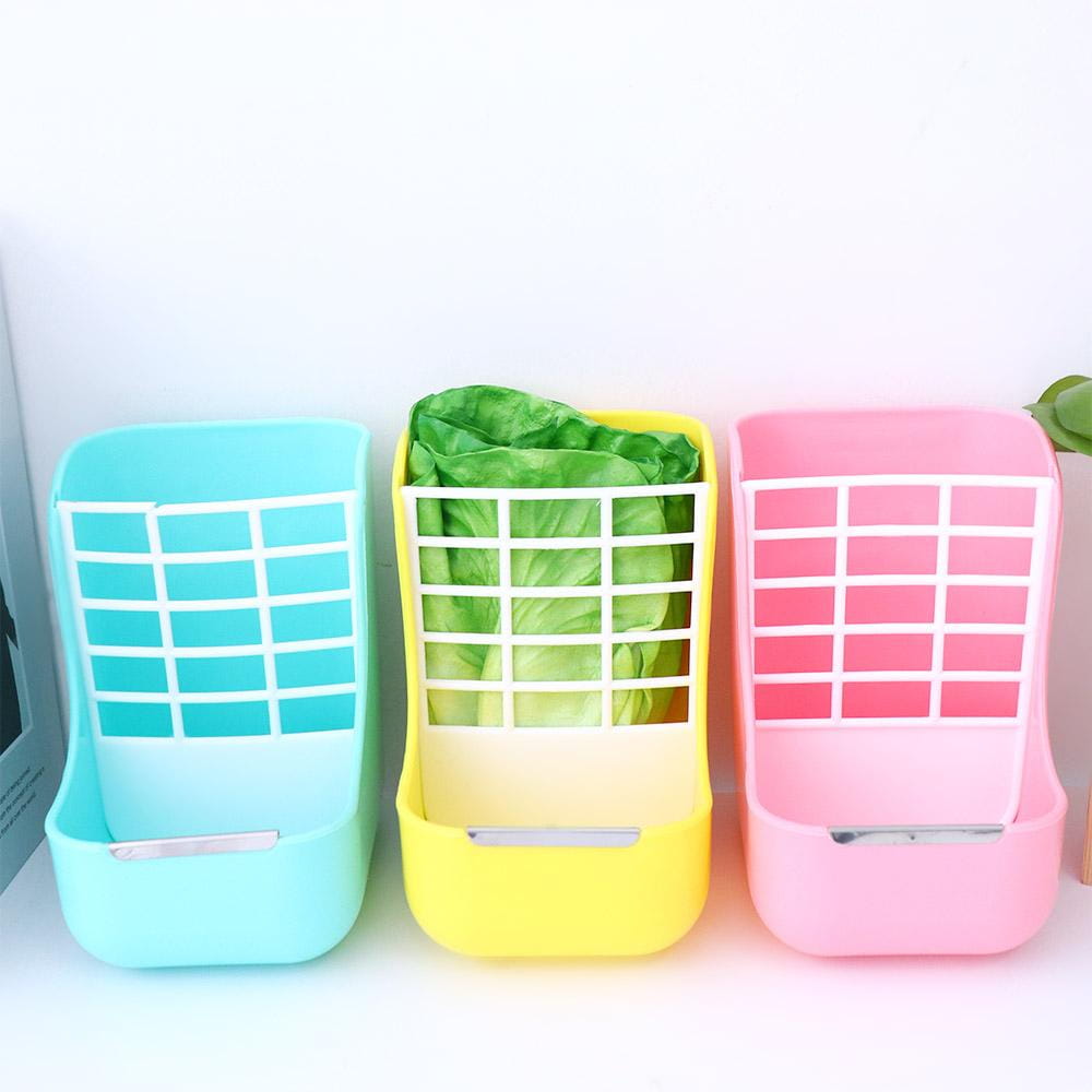 three colorful plastic wall-mounted rabbit hay feeders in light blue yellow and pink with white grid patterns designed for small animals with integrated food bowls