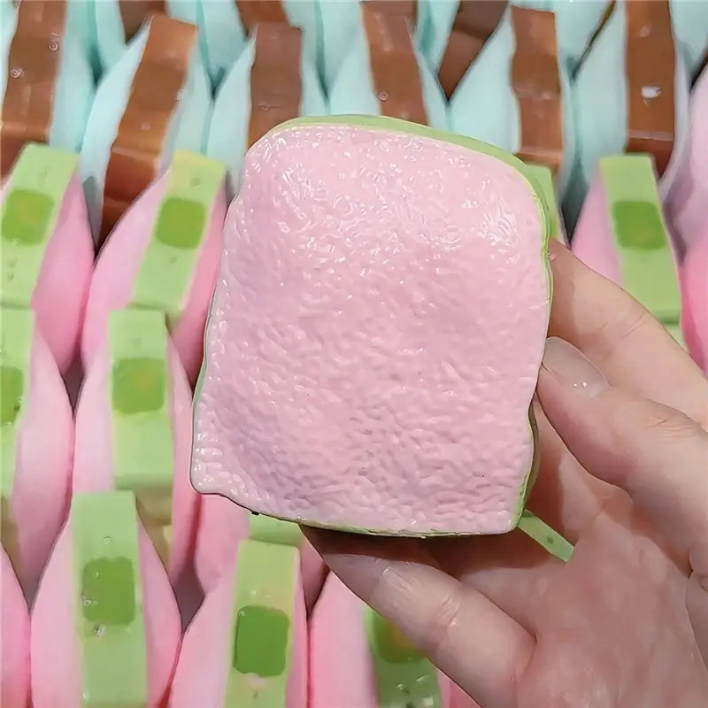 Butterstick- ASMR-Sensory-Squishy-Spielzeug, pink und grün, Silikon-Stresslinder in Form einer Scheibe Brot.