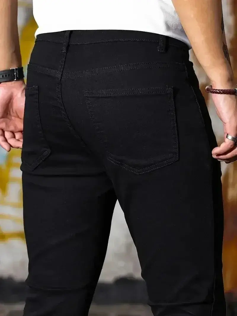 Jeans en denim bleu foncé coupe slim pour homme présentés de dos, avec des poches arrière classiques et une matière en denim noir.