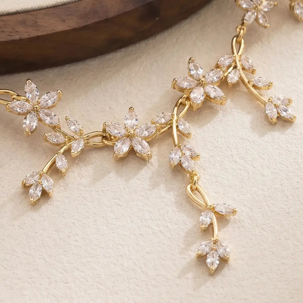 Zarte goldfarbene Kristall-Brautkette mit kunstvollen floralen Motiven, in einem rankenartigen Muster angeordnet, mit klaren, facettierten Kristallen.