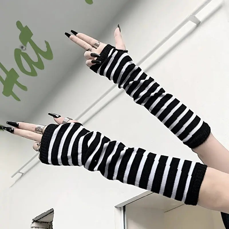 Black and white striped knit fingerless arm warmers showing the back side of the gloves.