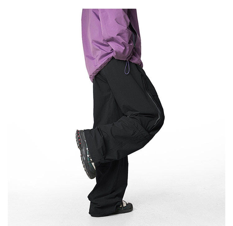 pantalones cargo impermeables de senderismo para hombre en negro, con corte ancho y relajado, bolsillos laterales visibles, diseñados para un rendimiento de secado rápido.