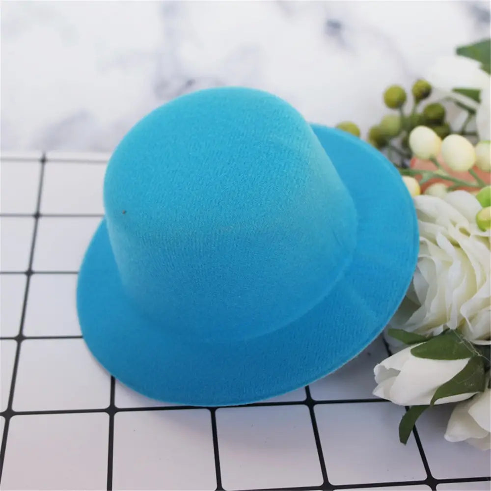 Un chapeau de poupée en peluche en feutre bleu éclatant, à calotte arrondie et bord large, conçu comme accessoire de mode pour des poupées de 60 cm.