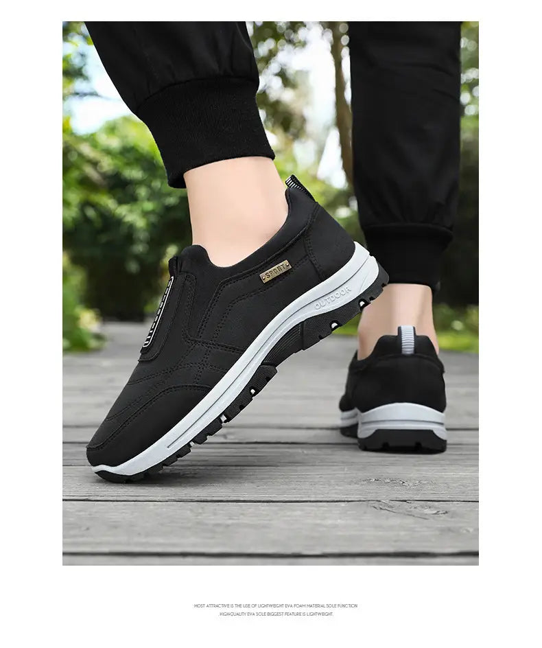 Men orthopedic slip-on walking shoes in black casual design with a white midsole, textured rubber outsole, and elastic side panel for easy wear.