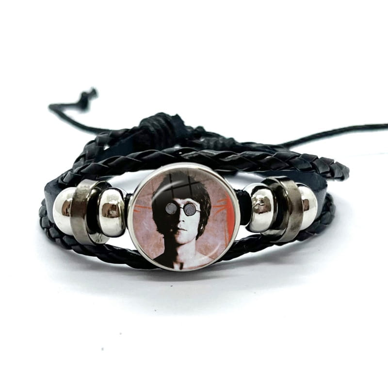 Black braided leather Beatles bracelet with circular glass dome charm featuring john Lennon portrait wearing sunglasses and silver-toned metal beads.