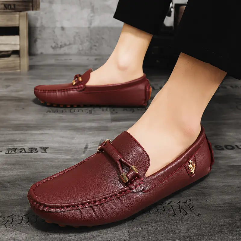 Les chaussures à enfiler habillées en cuir pour hommes en cuir bordeaux, avec des accents métalliques ton or et une couture au bout, pour un port décontracté sans effort.