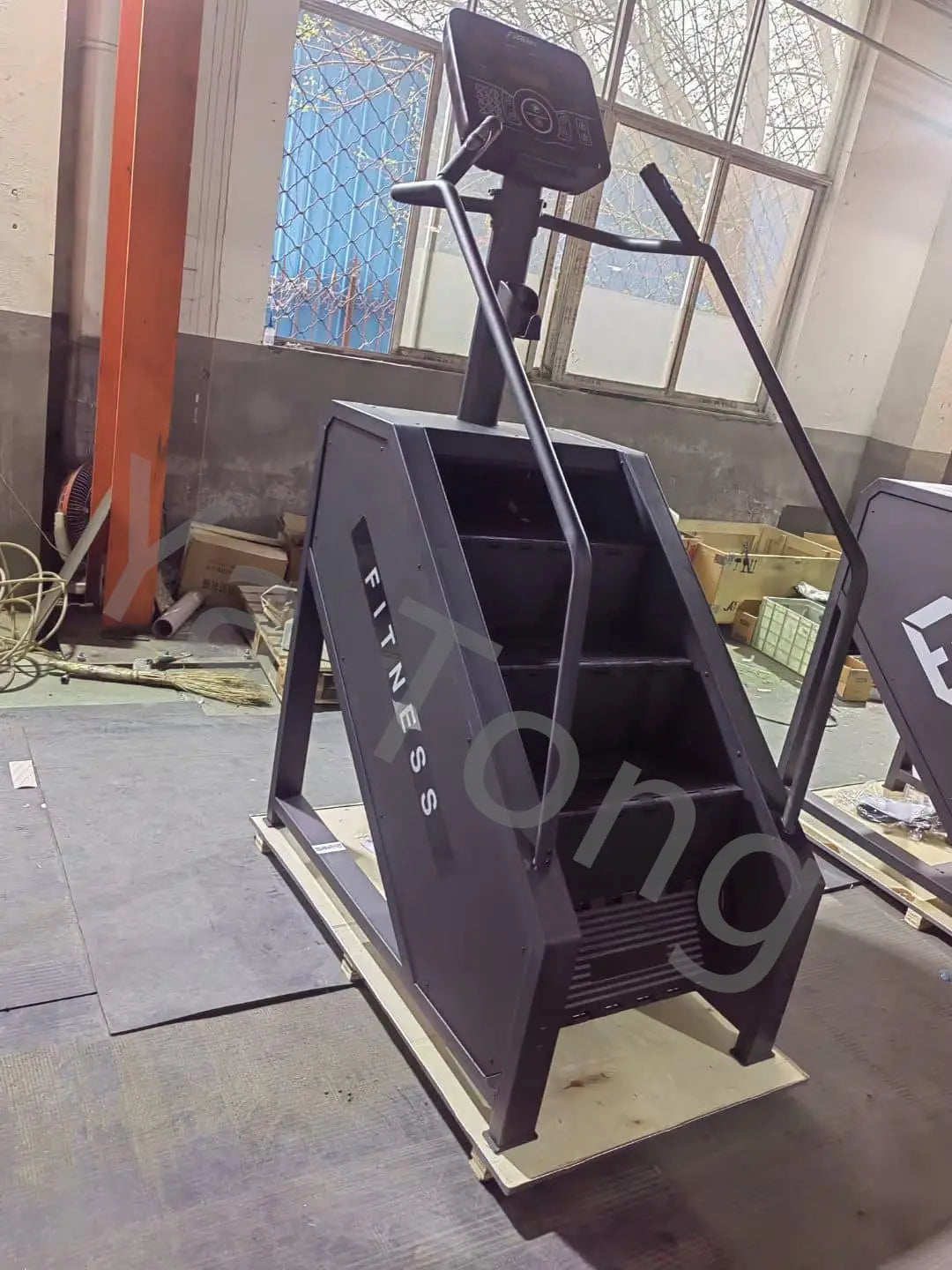 Black metal commercial stair climber machine cardio stepmill with digital display handlebars and fitness branding on its side.