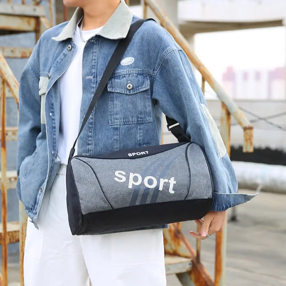 Sac de sport duffel gris et noir avec inscriptions sportives blanches, conçu comme un petit sac de salle de sport pour l’entraînement de remise en forme sportive.