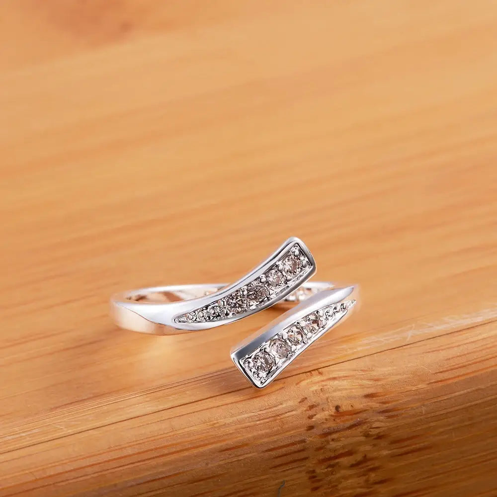 Offener, verstellbarer Ring aus Silber für Damen mit einem geschwungenen rechteckigen Band, besetzt mit klaren kubischen Zirkonia-Steinen, im Stil eines Zirkonrings aus 18k Gold.