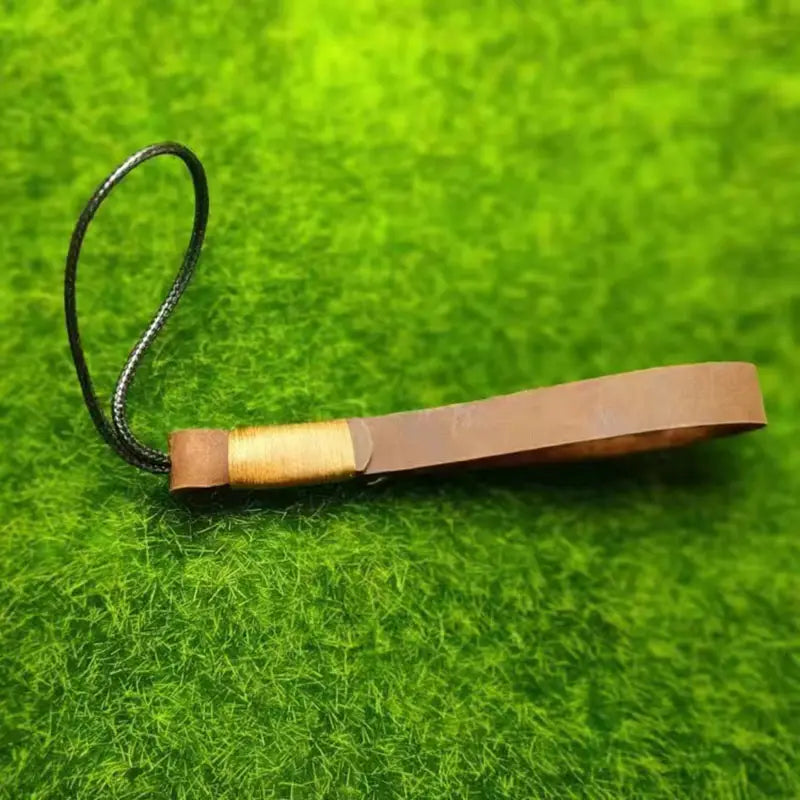 Leather weave lanyard keychain car key holder featuring brown leather with a black braided cord and gold-colored metal accent.