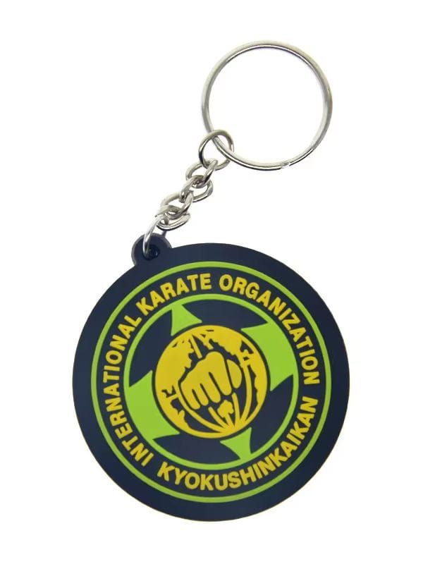 Custom soft PVC keychain in dark blue featuring a yellow fist gripping a globe emblem with green accents and international karate organization kyokushinkaikan text around the edge.