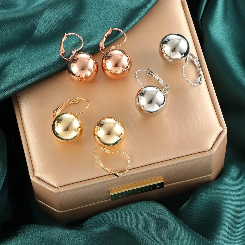 Conjunto de pendientes de tachuela esféricos con acabados en plata y oro amarillo, en oro rosa, con superficies metálicas pulidas para un uso diario elegante.