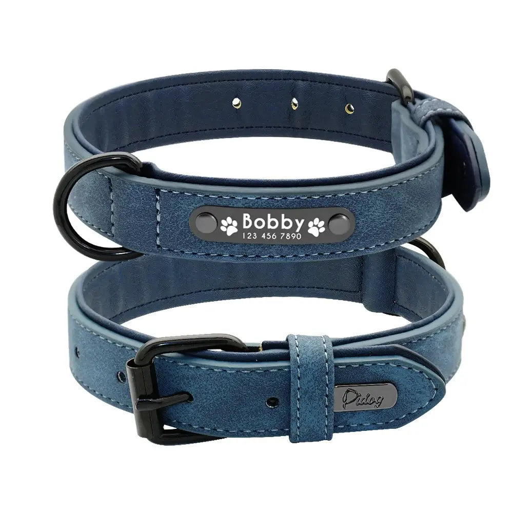 Customized leather dog collar in blue suede with black metal hardware and personalized engraved nameplate featuring the name Bobby and paw prints providing customization information.