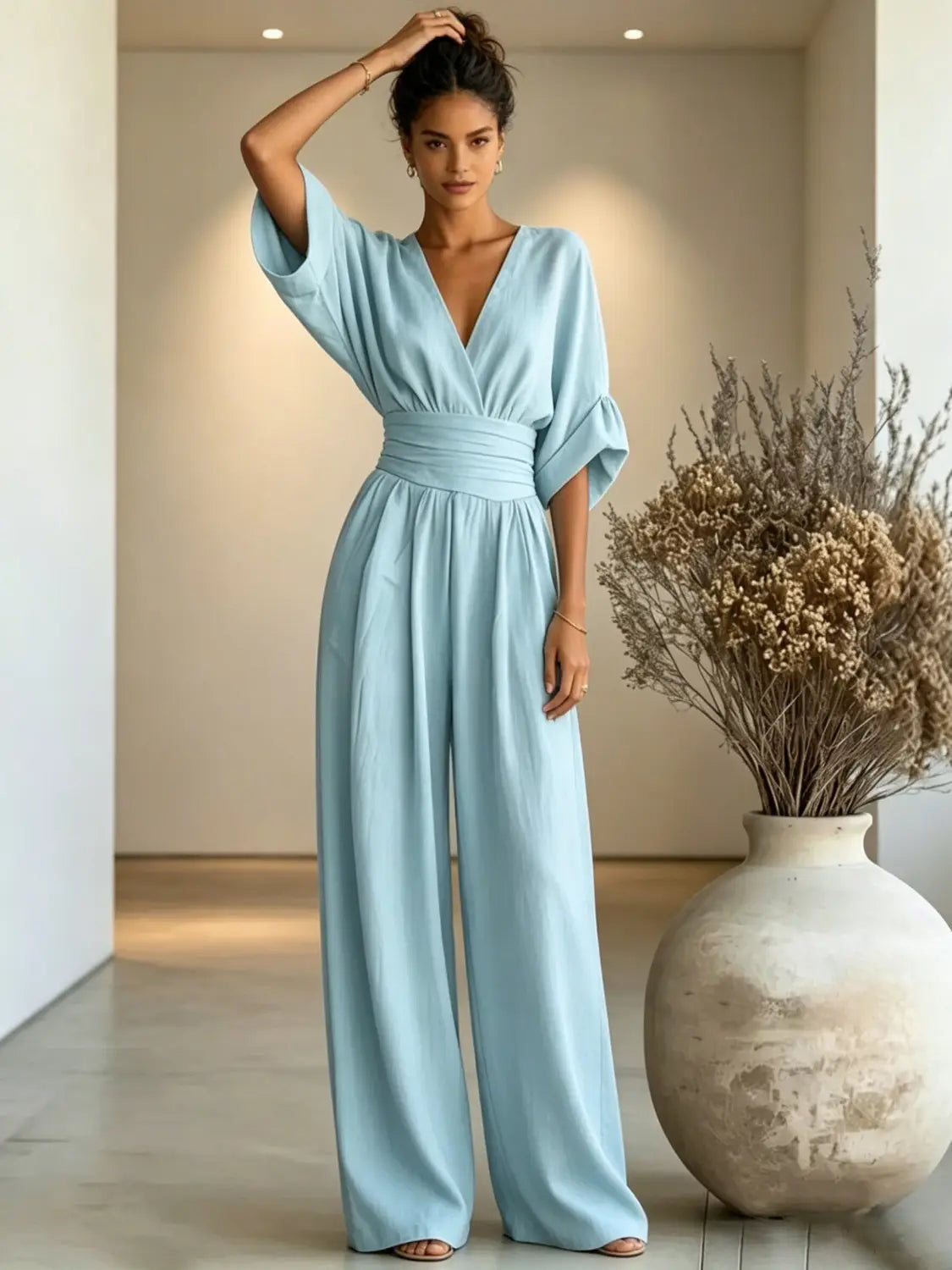 A flowing light blue satin v-neck wide-leg jumpsuit designed for elegant occasions.