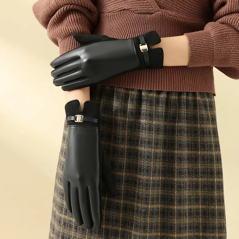Schwarze Damen-Winterhandschuhe aus Leder mit Touchscreen-Funktion, mit einem eleganten minimalistischen Design und einer kleinen goldfarbenen Schnalle am Handgelenk, von der Rückseite dargestellt.