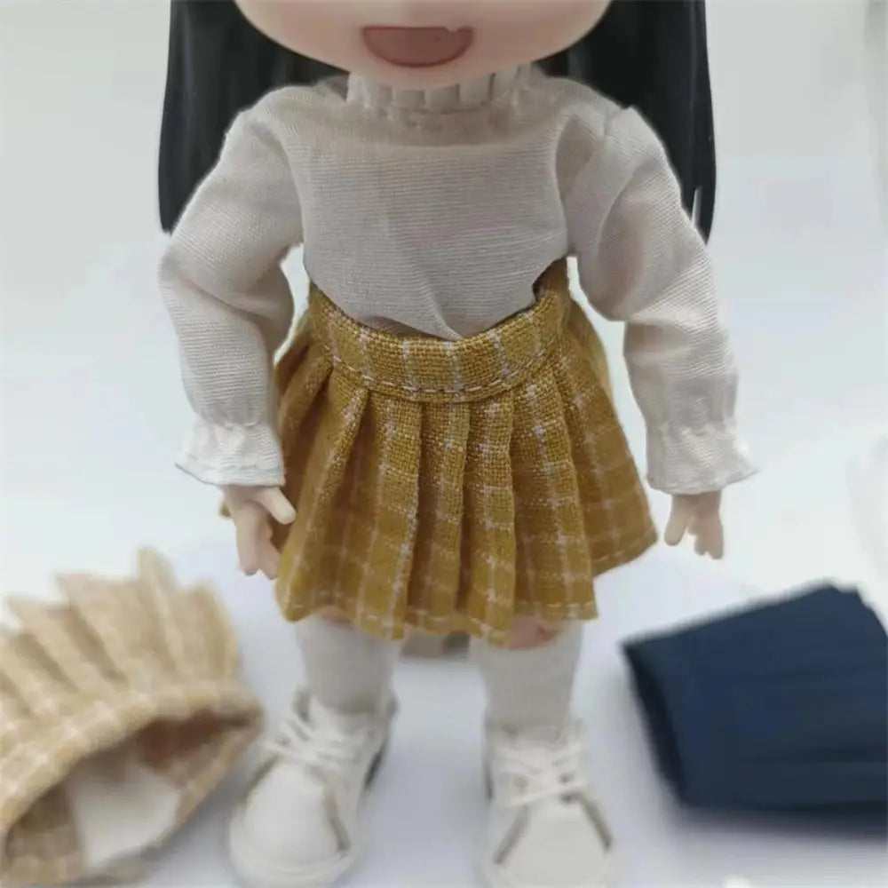 ゴールドのチェック柄をあしらい、立体感のある織り地を使用したハイウエストデザインのミニスカート風プリーツスカートが特徴のOb11ドールのミニスクール衣装。