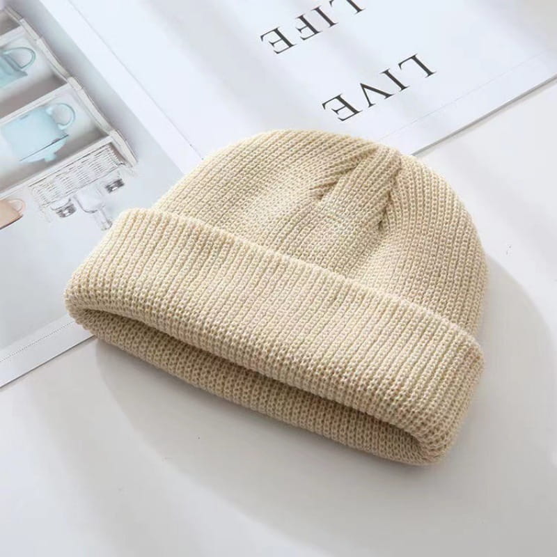 beige ribbed knit winter beanie hat with folded cuff made of warm knit material suitable for unisex use.