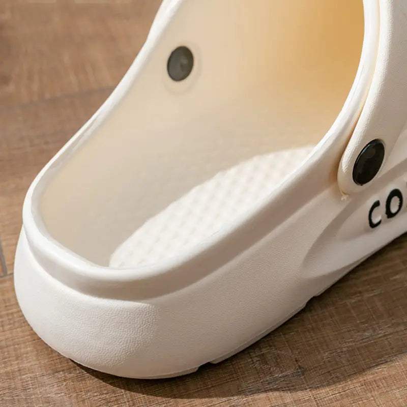 Weiße Eva Slip-on Cushion Clog-Sandale mit einer strukturierten Fußbettung und schwarzen runden Gummibefestigern.