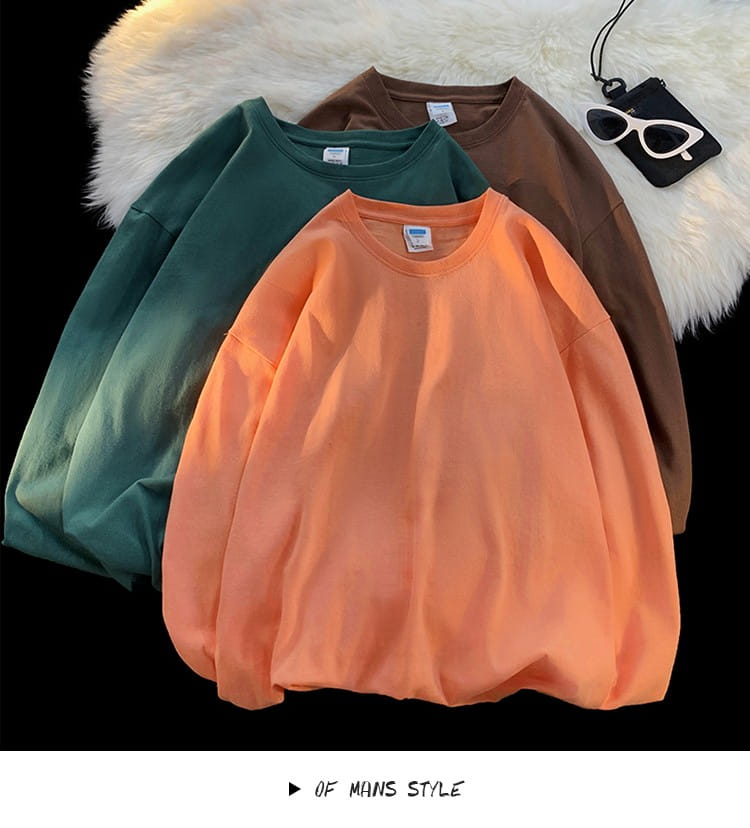 three oversized long sleeve blank crewneck t-shirts in solid orange green and brown made of soft cotton perfect for casual wear