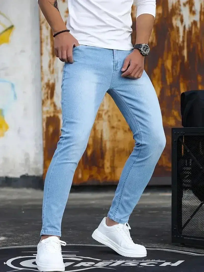 Jeans en denim bleu foncé coupe slim pour homme présentant un denim bleu clair coupe slim avec un lavage délavé et des coutures classiques
