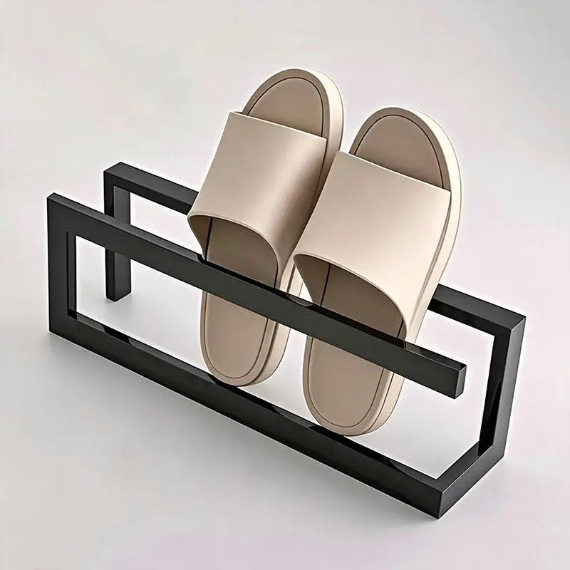 Beige Schlupf-Sandalen, die auf einem eleganten schwarzen freistehenden Metall-Schuhregal stehen, einem platzsparenden Halter für eine geordnete Aufbewahrung