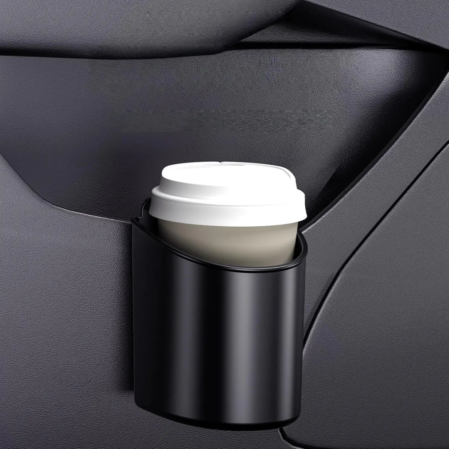 Black cylindrical car door cup holder with a matte finish holding a white-lidded coffee cup for vehicles.