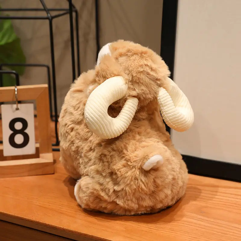 Eine Plüschschaf-Geschmacktier im niedlichen Kawaii-Weichpuppen-Design mit einem wolligen Körper in Hellbraun, gerippten Hörnern in Cremefarbe und einem kleinen weißen Schwanz.
