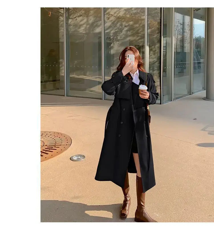 Black trench coat with a classic double-breasted design and long sleeves for casual windbreaker wear.