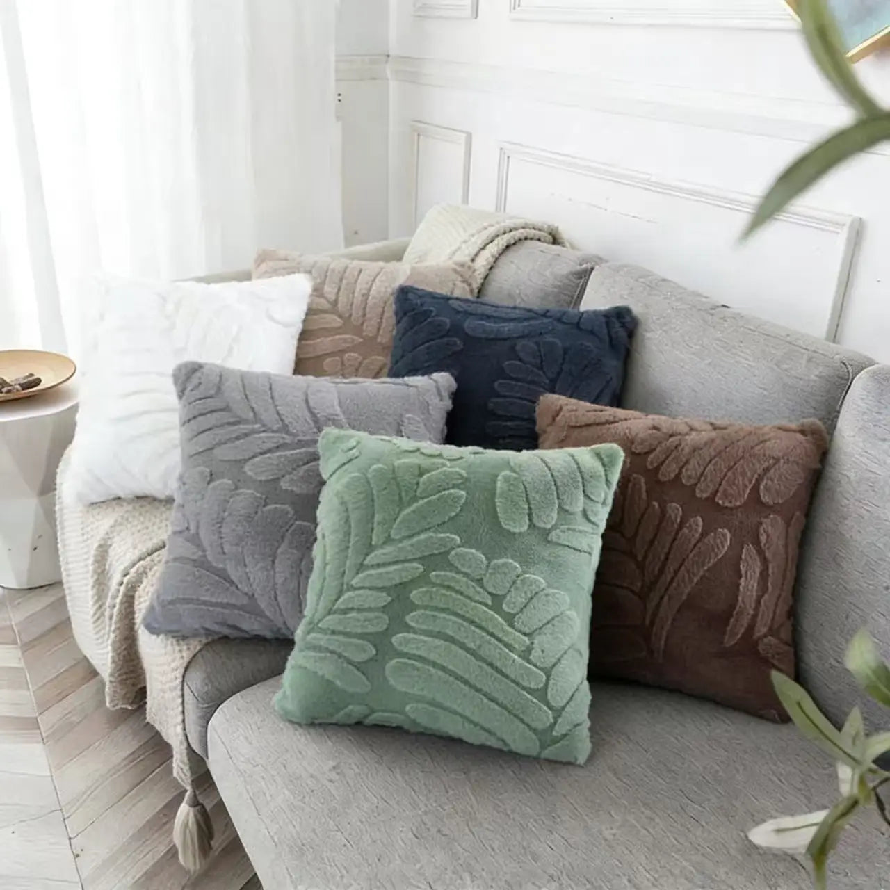 A plush square throw pillow cover in soft mint green featuring a raised leaf embroidery pattern.