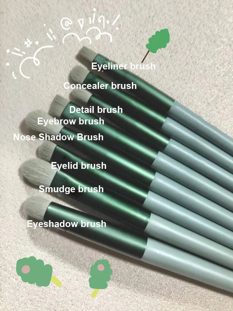 Set of seven green and gray eye shadow and face makeup brushes with labeled tips from the makeup brushes set 13 pcs rose gold cosmetic brush collection.
