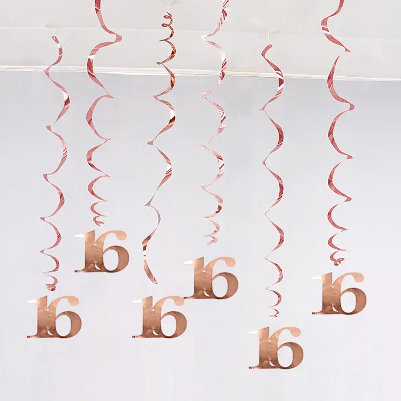 Guirlandes spirales métalliques doré rosé avec 16 découpes suspendues en hauteur dans le cadre de décorations en tourbillon d’anniversaire doré rosé, âges variés.