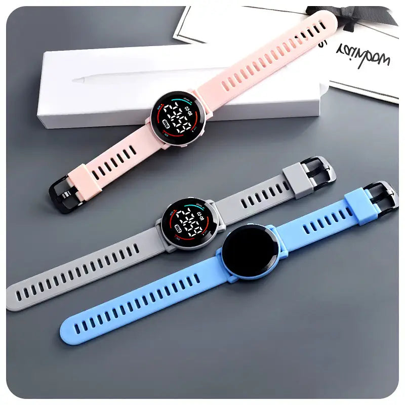 Three girls digital sports watches with waterproof led wristwatch feature and silicone straps in pink gray and blue.