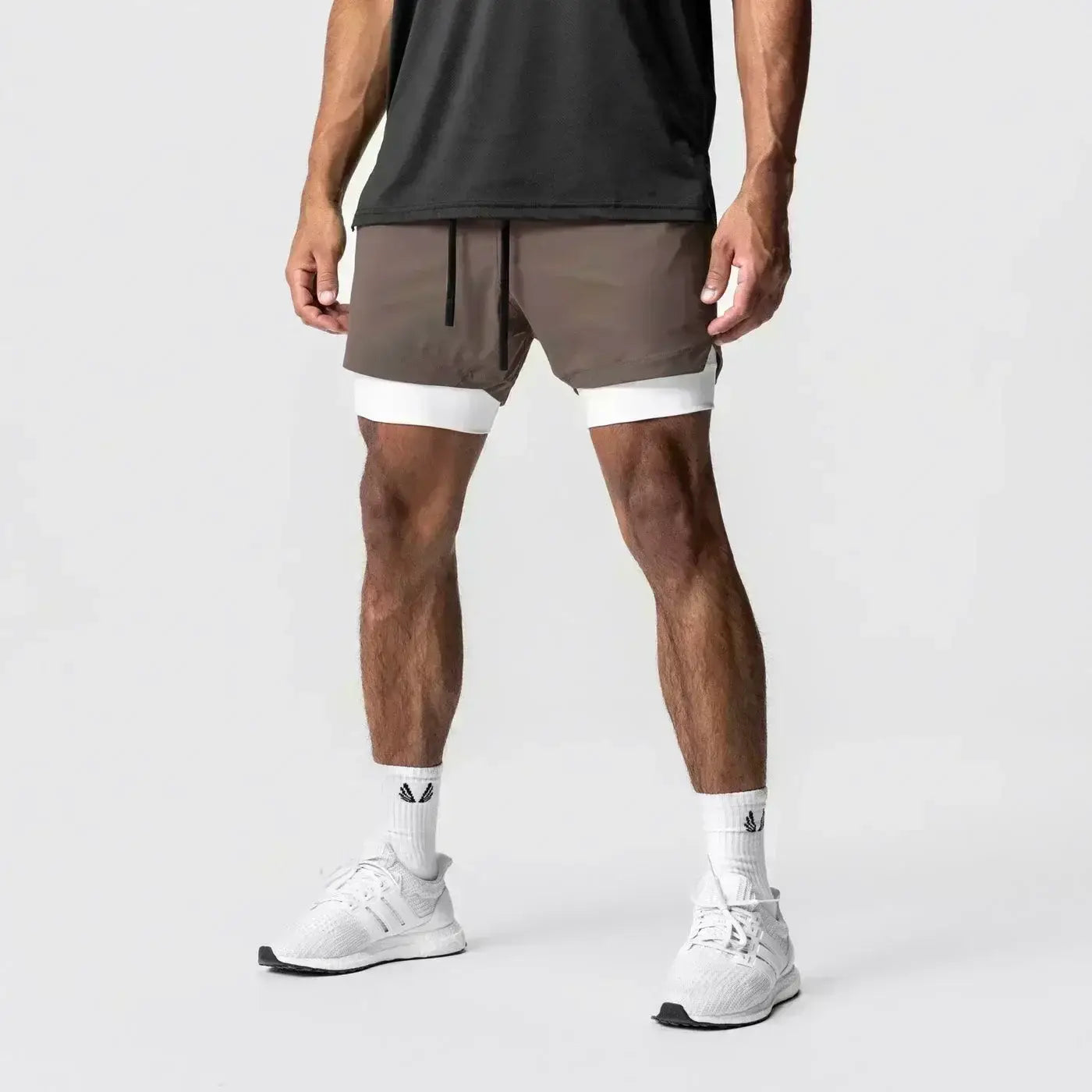Hombres, pantalones cortos atléticos 2 en 1 para gimnasio color marrón con forro interior blanco, cordón negro y trabilla para la toalla que ofrece soporte durante los entrenamientos.