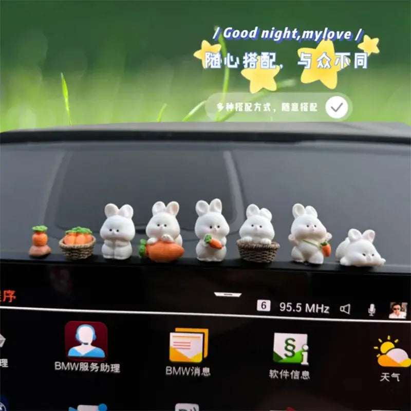 Une rangée d’adorables figurines de lapin en plastique blanc, tenant ou assises à côté de mini carottes orange ou de paniers, comme des ornements de tableau de bord de voiture