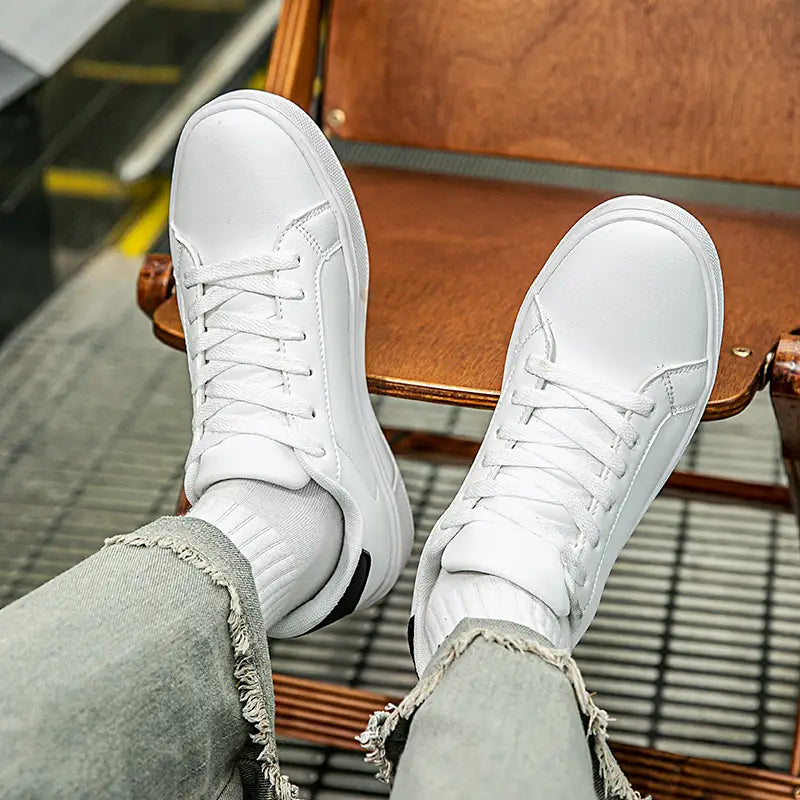 Weiße Ledersneaker im Freizeitstil, leichte Sportschuhe mit Low-Top-Design und schwarzen Akzenten an der Ferse, von der Rückseite dargestellt.