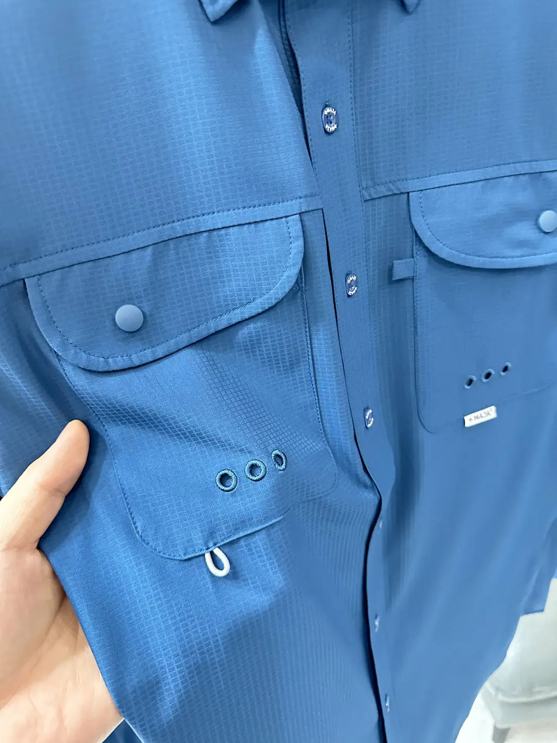 Men’s tactical outdoor long sleeve shirt in blue featuring two chest pockets with snap-button closure and reinforced stitching.