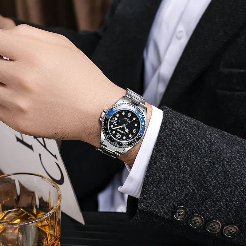 Quartz sport watch with silver-toned stainless steel case, black dial, blue bezel accents, white hour markers, and rubber strap.